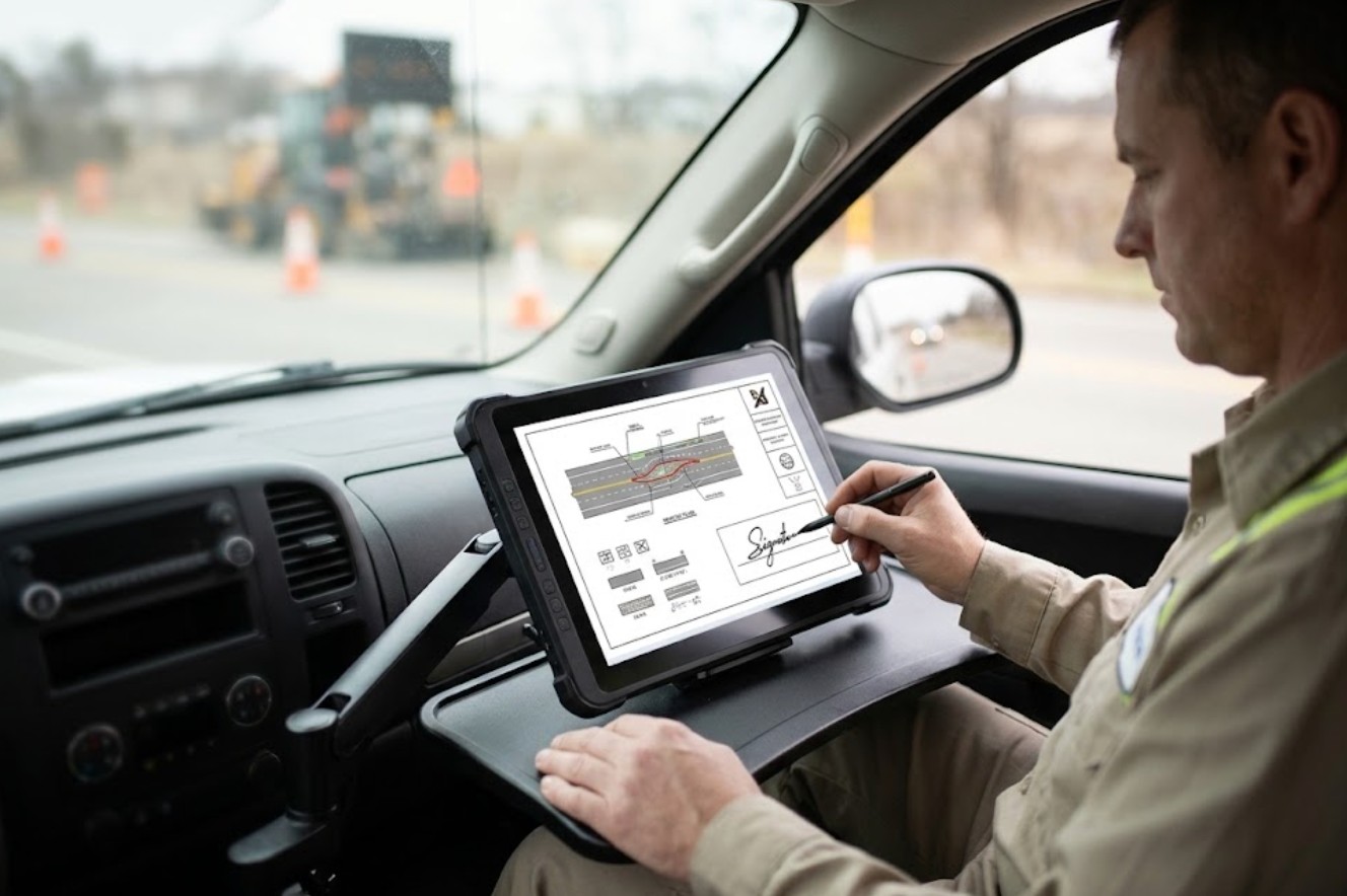 Crew chief reviewing and signing off repair plans on the ST13-U large rugged tablet mounted in the survey truck cab Crew chief reviewing and signing off repair plans on the ST13-U large rugged tablet mounted in the survey truck cab